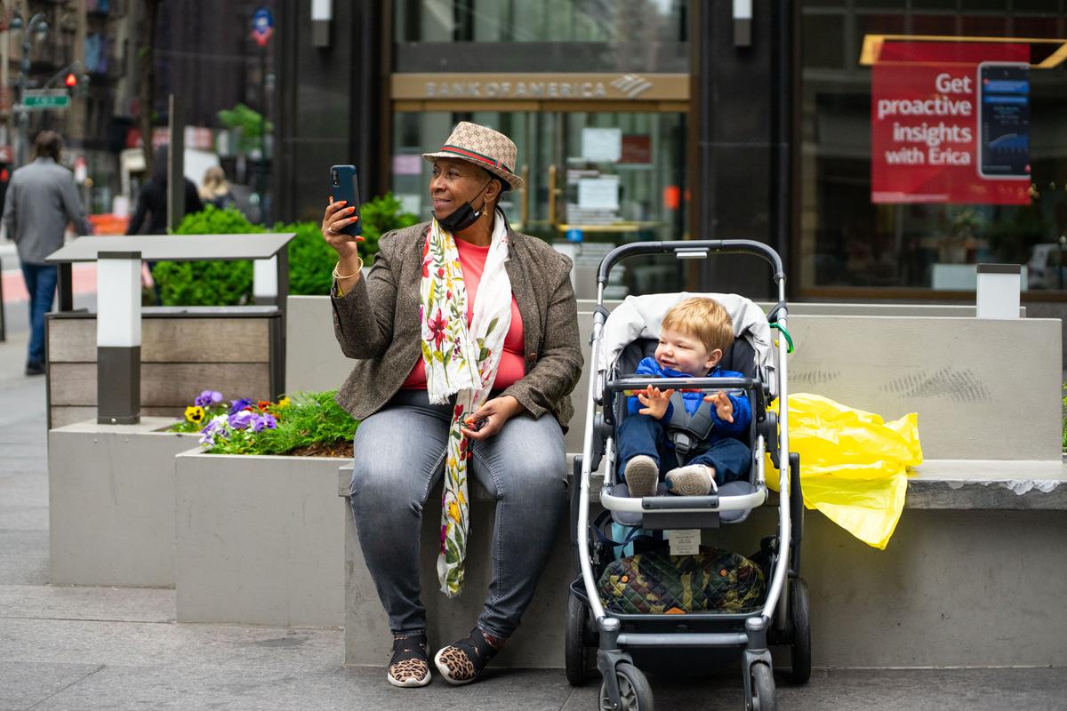 Pedestrians watch as Falun Gong practitioners take part in a parade marking the 30th anniversary of its introduction to the public, in Manhattan, New York, on May 13, 2022. (Chung I Ho/The Epoch Times)