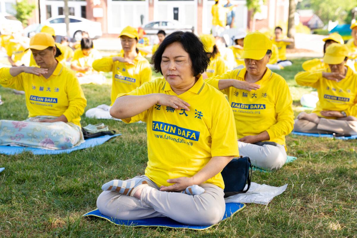 Falun Gong adherents meditate in a park in Goshen., N.Y., on July 17, 2022. A few hundred adherents of the spiritual practice gathered in the park to commemorate the 23 years since the Chinese Communist Party launched a persecution of their fellows in faith in China. (Larry Dye/The Epoch Times)