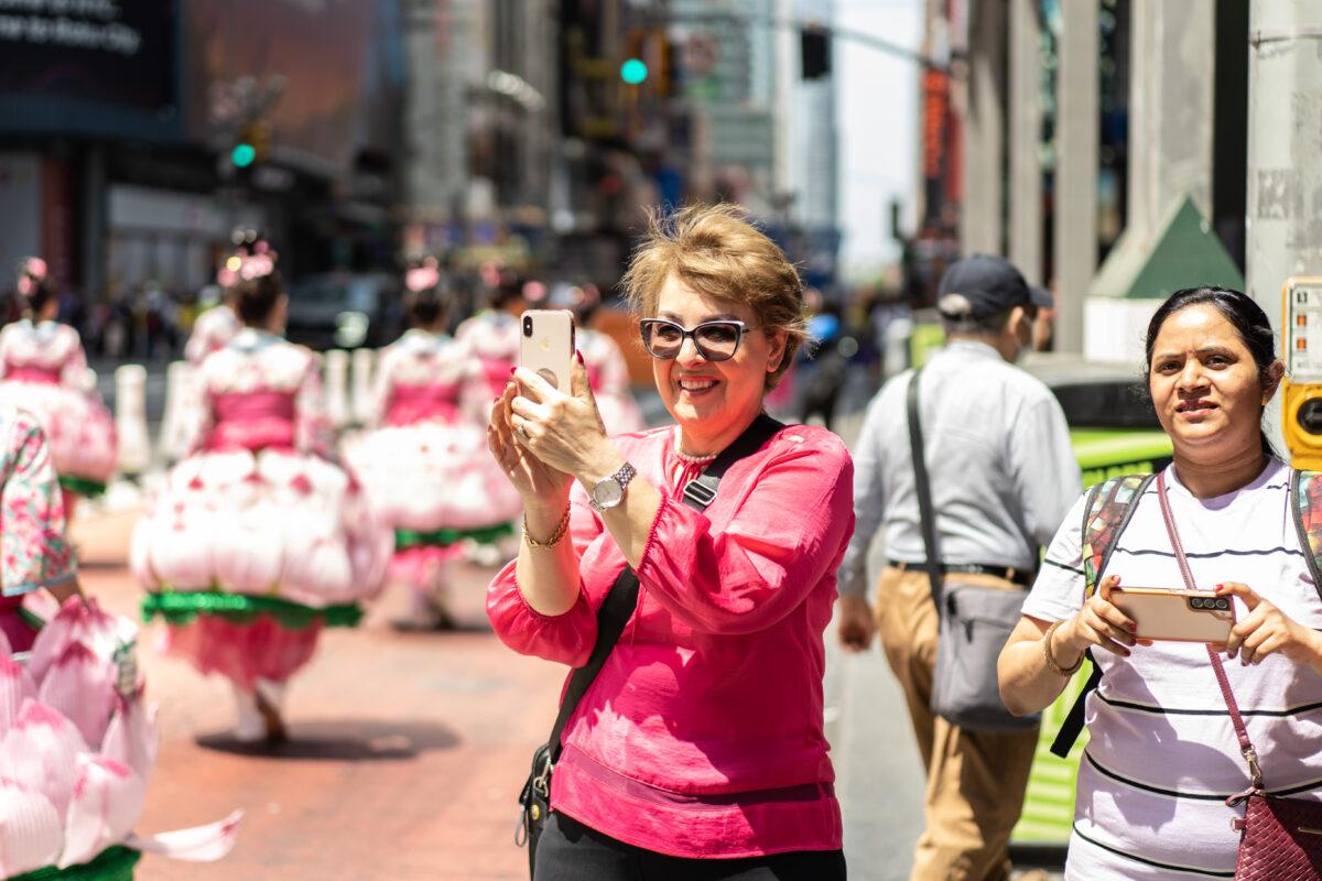 People look on as Falun Gong practitioners march in Manhattan to celebrate World Falun Dafa Day on May 12, 2023. (Samira Bouaou/The Epoch Times)