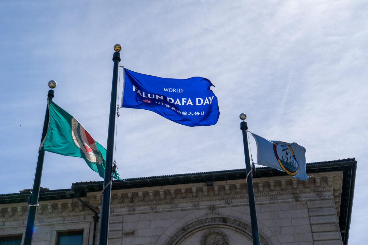 A World Falun Dafa Day flag outside the city hall in Worcester, Mass., on May 13, 2023. (Learner Liu/The Epoch Times)