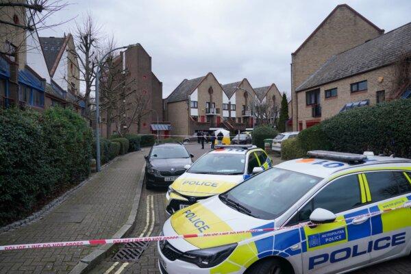Police guard the entrance to a road where a man armed with a crossbow was shot dead by police in Surrey Quays, London on Jan. 30, 2024. (PA)