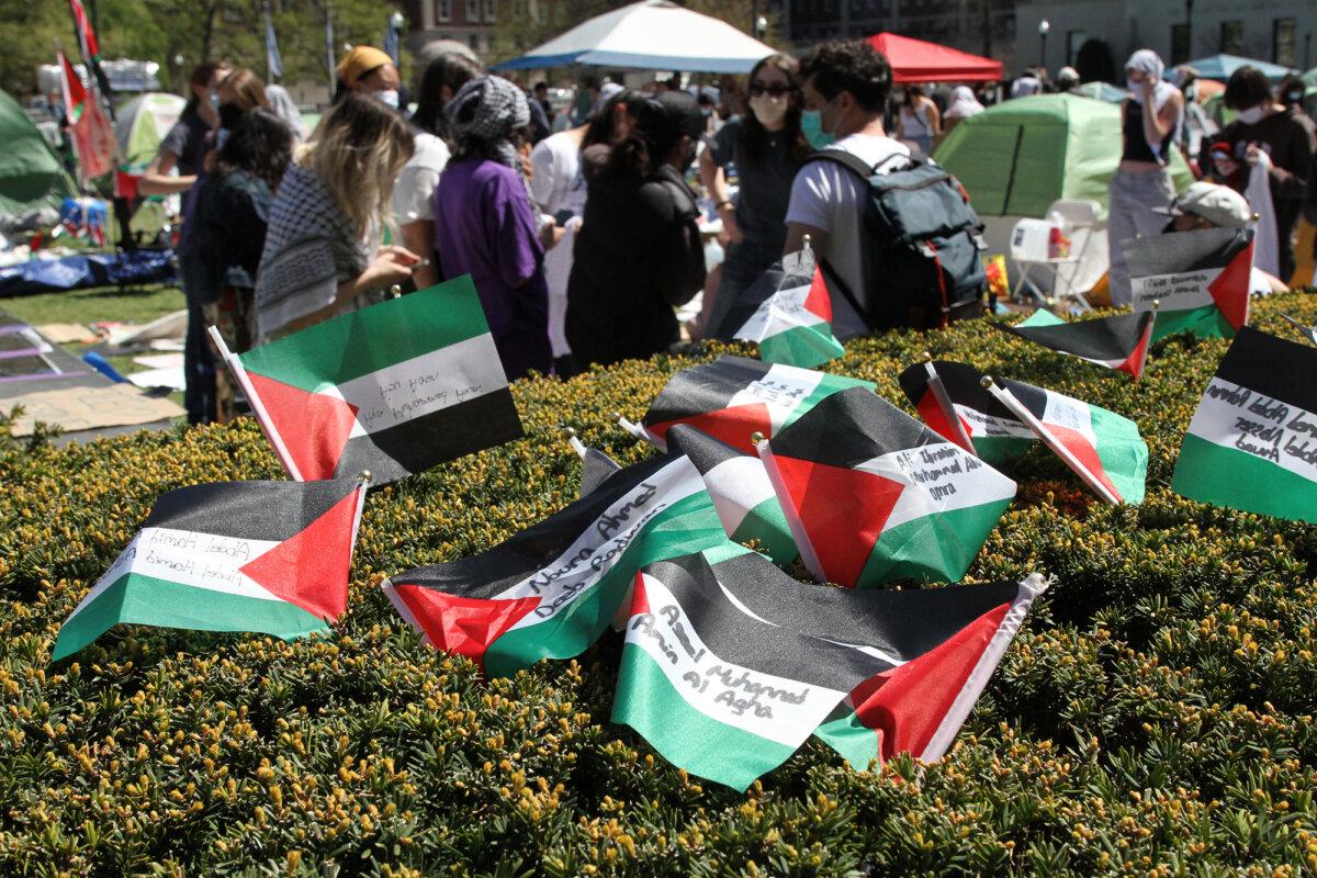 Palestinian flags sit in a hedge along the border of the protest encampment on the Columbia University campus in New York City on April 23, 2024. (Richard Moore/The Epoch Times)