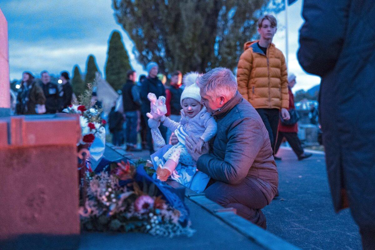 A young child with their parent looks at the wreaths laid at the base of the Cenotaph after the morning Dawn Service in Hobart, Australia on April 25, 2024. (Tamati Smith/Getty Images)
