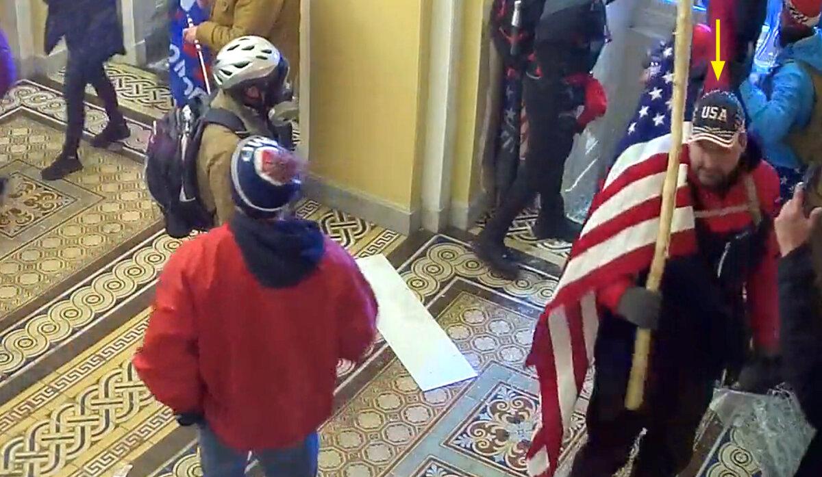 William Pope of Topeka, Kansas, carries an American flag just inside the Senate Wing Door at the U.S. Capitol on Jan. 6, 2021. (U.S. Capitol Police/Screenshot via The Epoch Times)