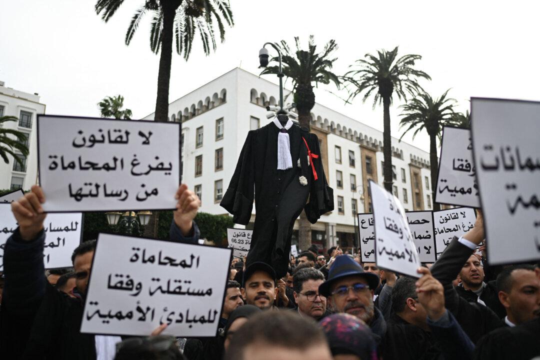 TOPSHOT - Lawyers hold placards as they take part in a protest in front of the Moroccan parliament in Rabat on February 6, 2026. Hundreds of lawyers from across the country gathered as part of an open-ended strike to oppose draft law 66.23 regulating the legal profession, which they say undermines the independence of lawyers and the right to a fair trial. (Photo by ISSAM ZERROK / AFP via Getty Images)